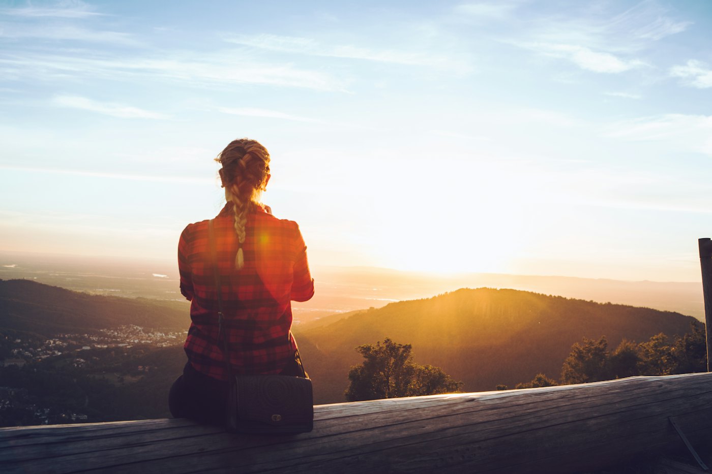 Person sitting alone watching the sunset over the Black Forest hills